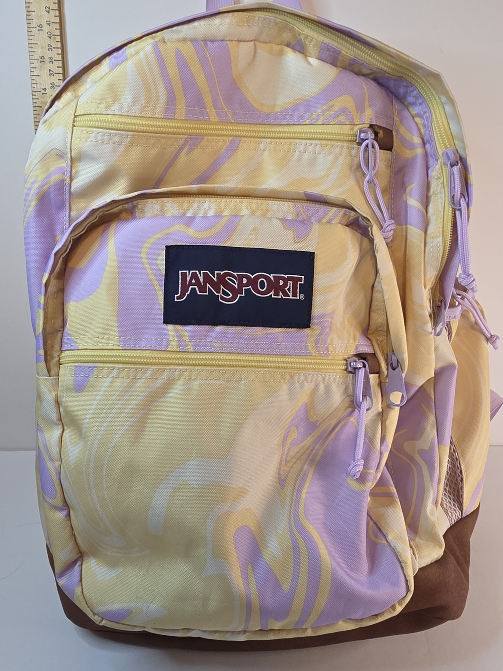 JanSport Swirl Print Backpack in Yellow & Lavender Marble Pattern $40